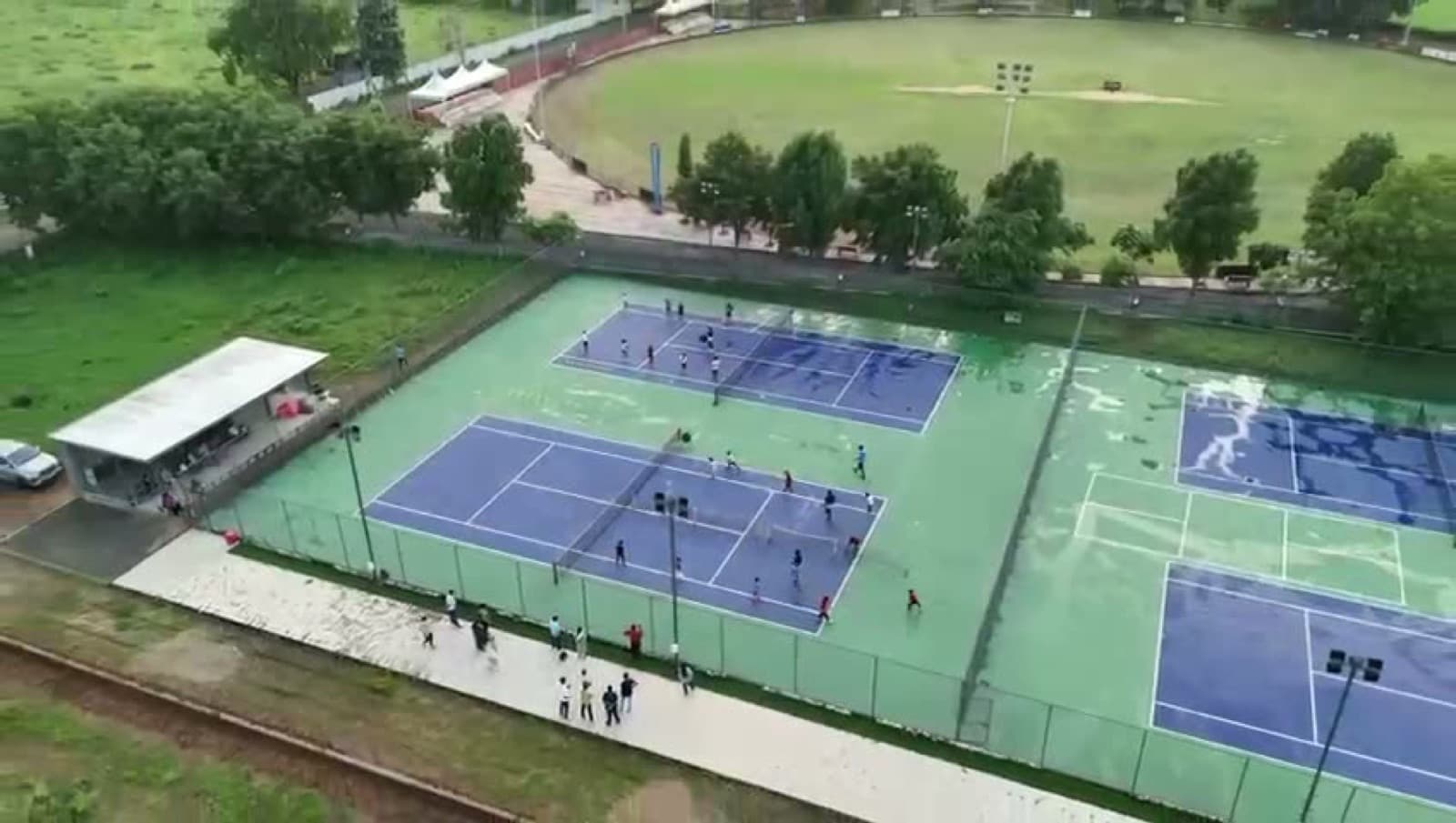 Coaching session in progress on the tennis courts at Drona Sports Academy